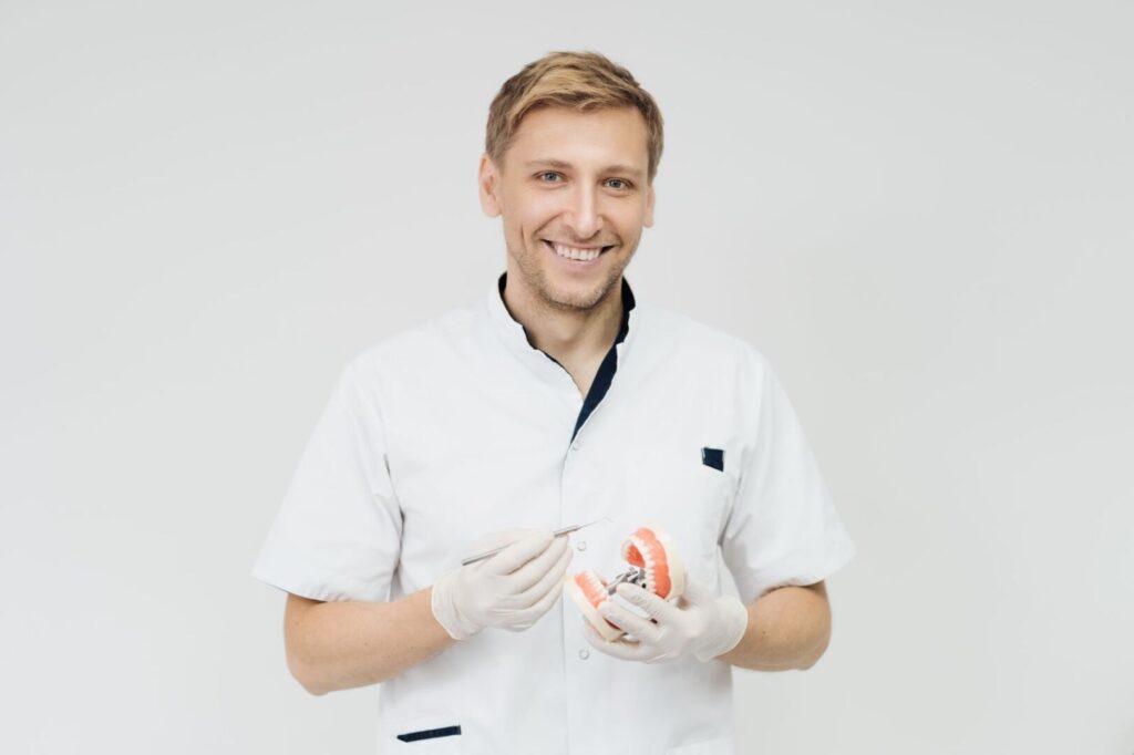 stomatologist doctor explaining proper dental hygiene patient holding sample human jaw